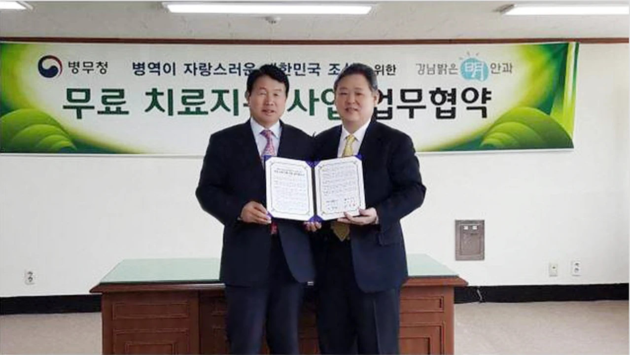 김노운 병무청 차장과 송명철 강남밝은명안과 원장이 무료 치료지원 사업 업무협약서를 들어보이는 모습